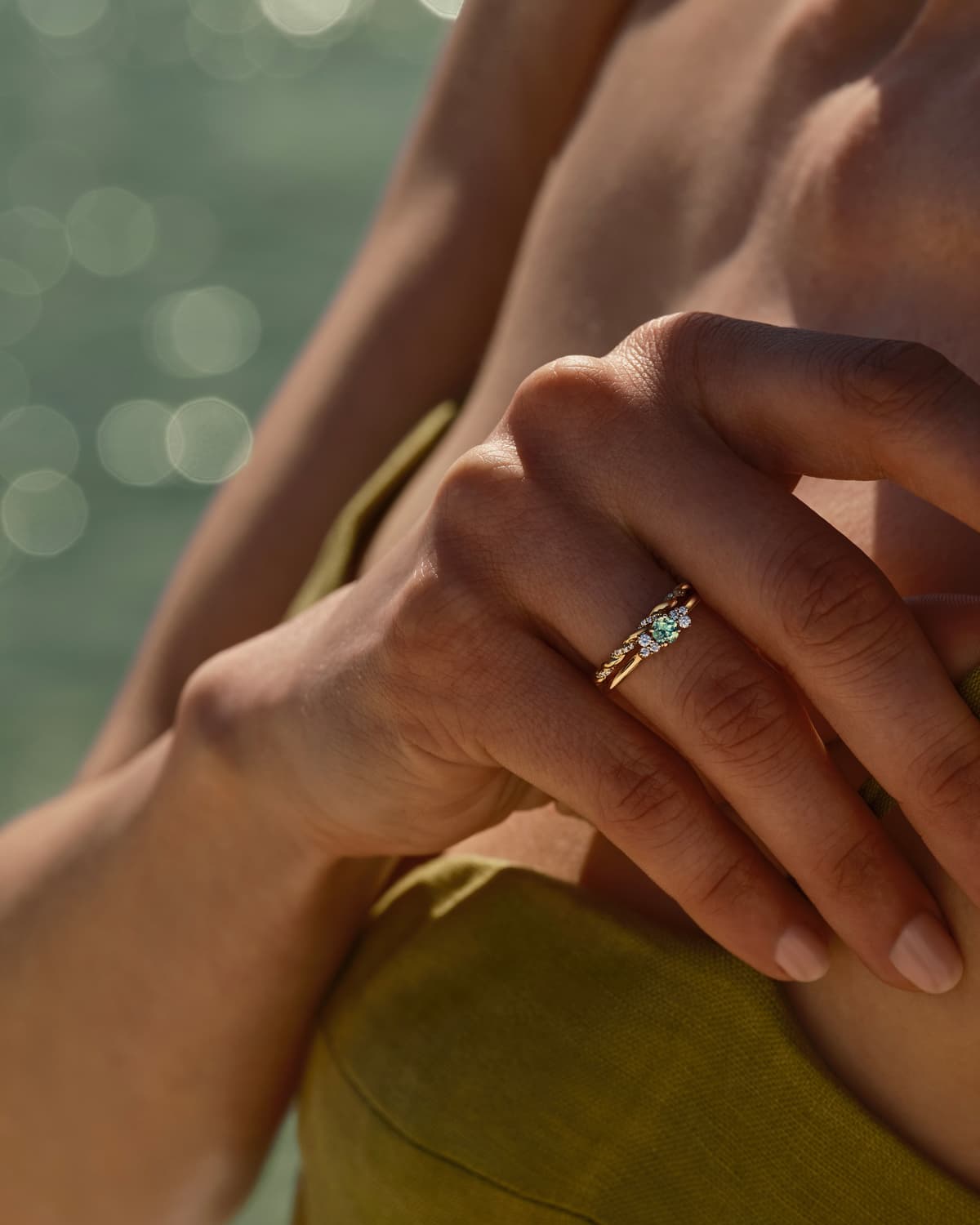 Model trägt den Baby EverBloom Ring aus Roségold und mint Turmalin in Akkumulation mit dem Capucine Pavée Ring aus Roségold und Diamant.