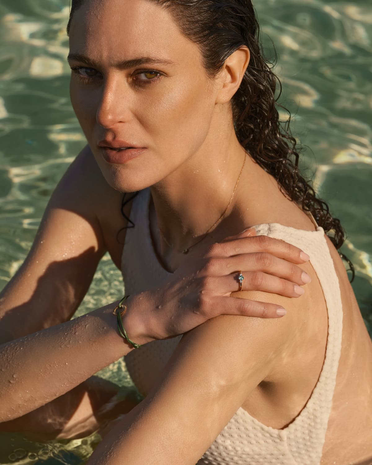 Model trägt den Baby Lady Duo Oval Ring aus Roségold und Turmalin Mint, den Lady Duo Anhänger aus Roségold und Turmalin Mint und das olivgrüne Cord Armband Entaille Rayons aus Roségold.