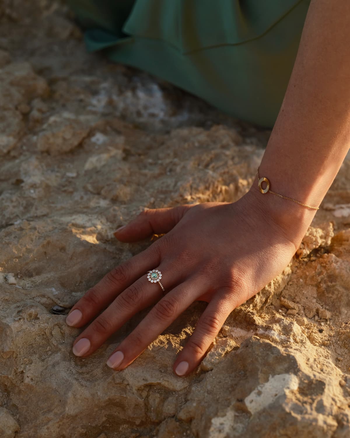 Hand eines Models, das den Ring Lefkos 4 mm Pavée aus Roségold und Turmalin Mint und das Armband Entaille Rayons S aus Roségold trägt.